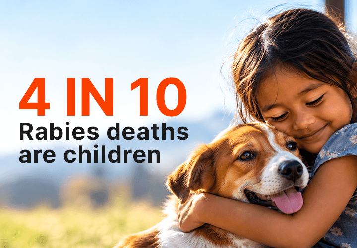 A young girl hugging a dog. 4 in 10 rabies deaths are children.